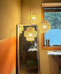 Dope Boho Plug In Pendant Light With Macrame Shade Two Pack Hanging Lights in bedroom reflects in a mirror.