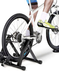 Cyclist using Magnetic Bike Trainer Stand For Indoor Cycling With Premium Steel Build Quiet Low Noise Operation Fits 26 To 28 Inch Wheels And 700C