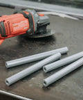 Heavy Duty 6061 Aluminum Spacer 5/8 OD X 5/16 ID X 36 Inch Long Unthreaded Round Standoff Bushing on workbench with grinder.