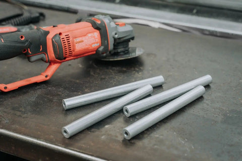 Heavy Duty 6061 Aluminum Spacer 5/8 OD X 5/16 ID X 36 Inch Long Unthreaded Round Standoff Bushing on workbench with grinder.