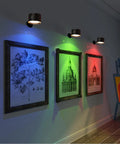 Rechargeable Battery Operated Wall Sconce Twin Pack With 3 White And 13 RGB LED Lights illuminating artwork in cozy corner