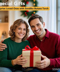 Couple sitting together holding a wrapped gift box in a holiday decorated room.