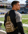 Man wearing Waterproof Tactical Crossbody Backpack With MOLLE System Outdoor EDC Sling Chest Bag on a sports field