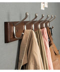 Beefy Wood And Zinc Alloy Wall Mounted Coat Rack With Rock Hard Hooks displaying multiple coats and bags organized on a solid wood frame.