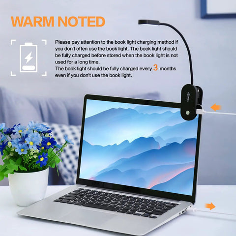 Laptop with Rechargeable Clip On Book Light With 14 LEDs Eye Care Amber Reading Lamp attached, showing charging process.