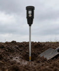 2-In-1 Soil Moisture Meter And PH Tester With A 12 Inch Probe, Portable Garden Tester inserted in soil beside a small shovel