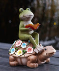 Solar Frog Riding Turtle Garden Statue For Outdoor Patio Yard Balcony Decor Totally Boss Gift For Garden Lovers With Auto Solar Power For Daylight Charging And Gentle Night Glow featuring a frog holding a book on a turtle with flower decorations