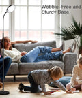 Modern Black LED Floor Lamp That Shines Brighter For Cozy Living Room Ambiance beside family on sofa with kids playing