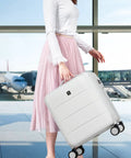 Woman holding 16 Inch Underseat Carry On Luggage With Spinner Wheels Hard Shell Suitcase For Airline Approved TSA Travel Gear Lightweight 29L Capacity Fits Overhead Or Under Seat Smoke White in airport
