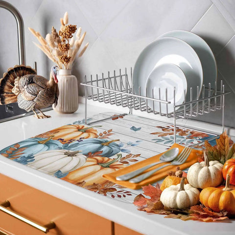 Fall Thanksgiving Dish Drying Mat Set 2 Pack Must Have With Pumpkin And Autumn Leaves Wood Grain Design Absorbent Microfiber Cushioned Surface For Countertop Dishes Drying And Quick Dry Machine Washable 18 By 24 Inches showing a festive autumn kitchen scene with pumpkins and dishes.