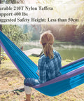 Person sitting in 400 Lb Capacity Portable Camping Hammock With Quick Setup Under 3 Minutes in nature