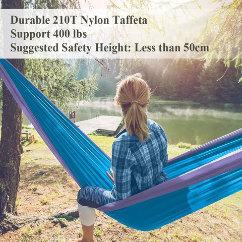 Person sitting in 400 Lb Capacity Portable Camping Hammock With Quick Setup Under 3 Minutes in nature