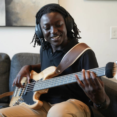 Person playing bass guitar with Dope Tone Wired Smart Guitar Headphone Amp With Custom Audio Drivers Noise Isolation