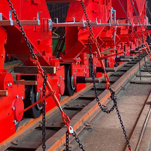 Heavy Duty G80 Chain Binder Set 3/8 to 1/2 Inch With 3/8 Inch By 10 Foot Chain, securing large red machinery on tracks