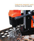 Heavy Duty Magnetic Drill Featuring Adjustable Speed And Forward Reverse Tapping Functions Delivering Smooth Steel Drilling And Industrial Metalwork That Goes Off Without A Hitch, working on a steel plate with metal shavings.