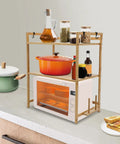 Top Shelf Heavy Duty Double Tier Microwave Stand With Cutting Board Holder And Four Utensil Hooks For Countertop Storage Kitchen Organization No Sweat Setup with cookware and spices.