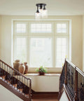 Three Light Industrial Tiered Matte Black Flush Mount Ceiling Light With Clear Glass Shade in a bright entryway