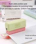 Grab And Go 5 Hole Paper Puncher Mini Handheld Circle Punch Tool punches a sheet with ruler guide for A4 A5 B5 sizes in an office setup