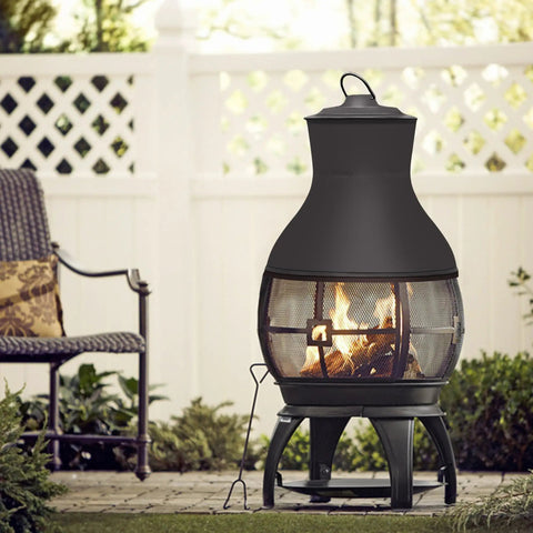 Compact Wood Burning Chiminea Fire Pit For Outdoors in brown black cast iron emitting warm fire on a small patio.
