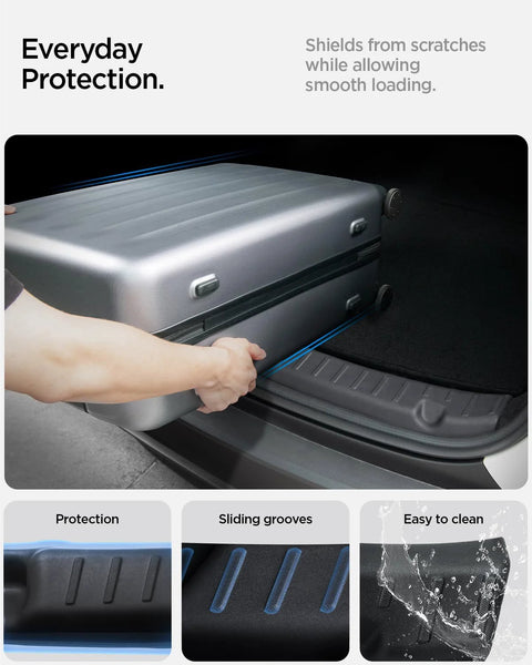 Spigen black rear bumper trunk sill guard for Tesla Model Y; installed, shown while loading luggage.