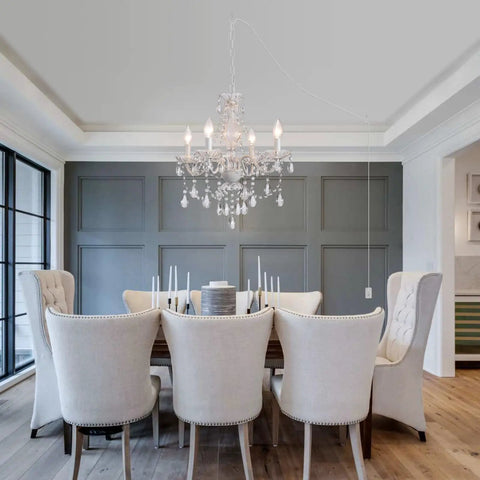 Plug In Crystal Ceramic White Chandelier With Clear Cord And Toggle Switch over a dining table with beige chairs in modern setting.