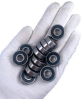 608 2RS Ball Bearings Set 100 Pack 8x22x7mm Sealed Chrome Steel, held in a hand, for skateboards, inline skates, and 3D printers.