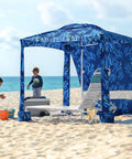 Beach Cabana Canopy 6.5 Feet By 6.5 Feet, Easy Set Up And Take Down, Portable Sun Shade With Sand Pockets And Side Wall, Water Resistant Beach Shelter In Coral Tropical on a sandy beach with children playing nearby.