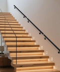 Flush Wall Mounted Stainless Steel Handrail Featuring Heavy Duty Sleek Black Cylinder With Rock Solid Grip Along Staircase.
