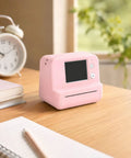 Next Level AI Voice Control Mini Thermal Printer With Color Display Generates Sweet Instant Sketches And Doodle Art Via Easy Phone App For Creative Folks Who Want Smooth Printable Vibes In Bright Pink Edition on a desk with notebook