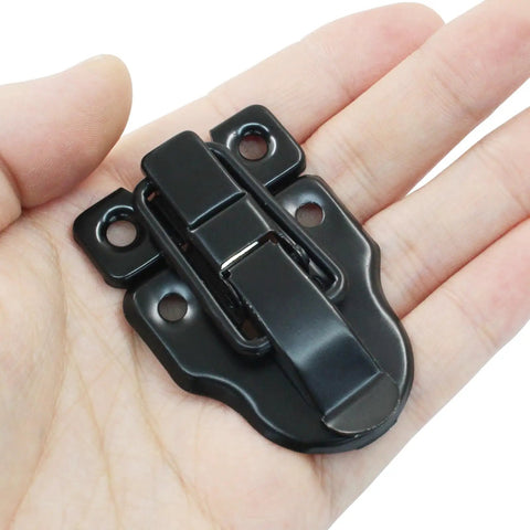 Four Pack Retro Black Box Toggle Latch With Padlock Hole in hand, antique brass finish, heavy-duty iron, ideal for jewelry boxes and cabinets.