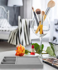 Slick Velvet Jewelry Tray With Anti Scratch Compartments For Rings And Bracelets Includes Dual Grid Foam Inserts on a table with makeup brushes and supplies.