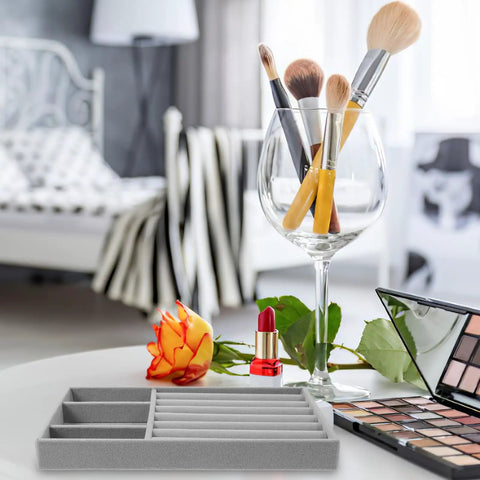 Slick Velvet Jewelry Tray With Anti Scratch Compartments For Rings And Bracelets Includes Dual Grid Foam Inserts on a table with makeup brushes and supplies.