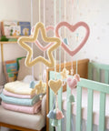 Aluminum Craft Wire and Acrylic Yarn Kit for I Cord Knitting Beginners Includes Eight 25 Gram Yarn Skeins and Two Rolls of Five Meters by Three Millimeter Wire for Easy DIY Handicraft Projects featuring baby mobile with knitted stars and hearts in pastel colors.