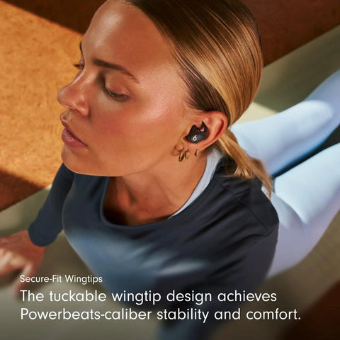 Woman wearing Powerbeats Fit Wireless Earbuds With Secure Wing Tips For Gym Workouts, focused during exercise on yoga mat.