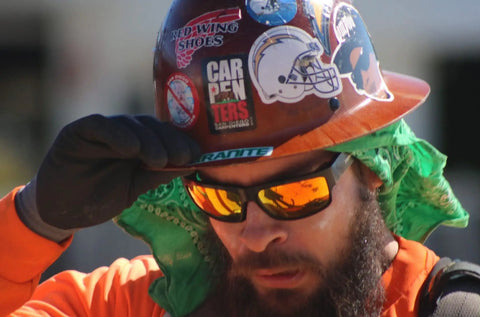 Worker wearing Tiger Safety Sunglasses With Dope Matte Black Frame And Red Mirror Lens ANSI Z87 Plus Certified 100 Percent UVA UVB Protection.