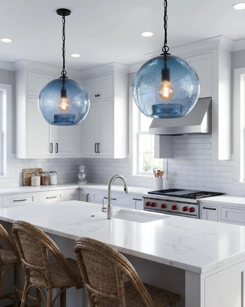 CASAMOTION Modern Farmhouse Blue Glass Globe Pendant Light 11" Dia. hung in kitchen with white cabinets and marble countertop.