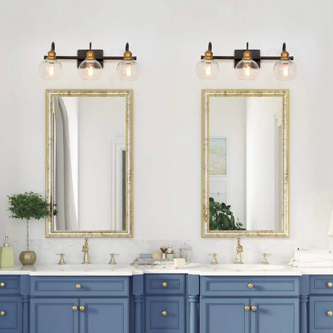 Twin dope three light vanity fixtures above blue sink, oil rubbed bronze, antique gold sockets, clear glass globes, vintage modern glow.