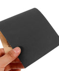 Hand holding a sheet from Wet And Dry Sandpaper Sheets Kit With Silicon Carbide Grit For Metal Wood Furniture Cars And Electronics