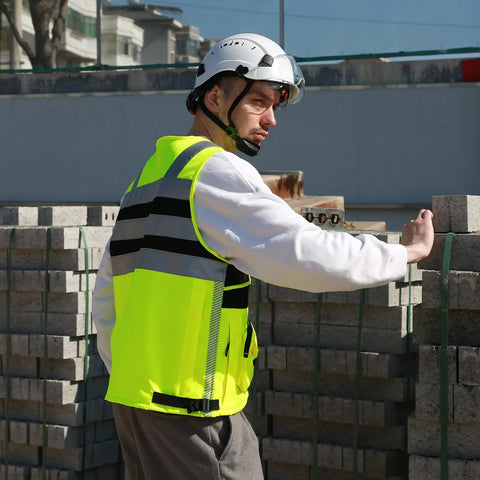 High Visibility Reflective Safety Vest With Heavy Duty Construction And Plenty Of Pocket Space For Tools On Any Job Site Hella Bright Orange Unisex Work Vest In Three X Large Size, worn by worker on site.