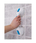 Hand holding 12-Inch Suction Shower Grab Bar with Ultra Grip Dual Locking Cups for strong stability in bathtubs and showers