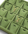 Close-up of Top Shelf Velvet Jewelry Tray With 24 Individual Sections For Pendants Folded Chains And Stud Earrings with gold necklaces.
