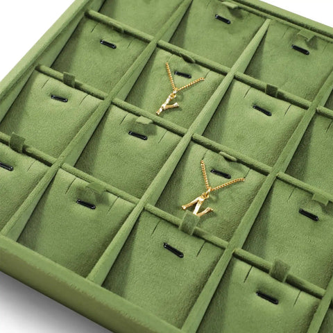 Close-up of Top Shelf Velvet Jewelry Tray With 24 Individual Sections For Pendants Folded Chains And Stud Earrings with gold necklaces.