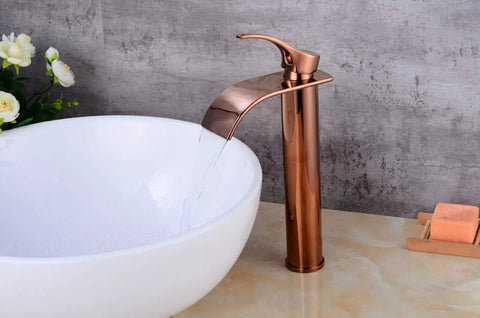 Waterfall Single Lever Vessel Lavatory Basin Tap In Rose Gold Oil Rubbed Bronze Finish next to a white sink