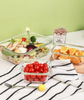 8 Pack Glass Food Storage Containers With Airtight Locking Lids For Meal Prep And Leftovers Leak Proof Design Microwave Oven Freezer And Dishwasher Safe BPA Free Variety Size Set For Portion Control And On The Go Lunches arranged with salad, oranges, and tomatoes on a kitchen counter.