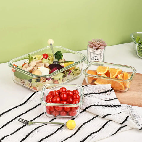8 Pack Glass Food Storage Containers With Airtight Locking Lids For Meal Prep And Leftovers Leak Proof Design Microwave Oven Freezer And Dishwasher Safe BPA Free Variety Size Set For Portion Control And On The Go Lunches arranged with salad, oranges, and tomatoes on a kitchen counter.