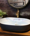Heavy Duty Premium Top Shelf Oval Ceramic Vessel Bathroom Sink For Countertop Installation With Slick Non Porous Glaze And Smooth Drainage For Restrooms displayed on wooden countertop with water reflection.