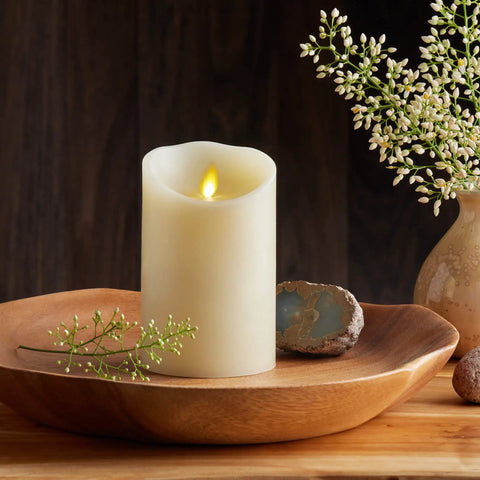 Cozy Ivory Flameless LED Pillar Candle With Moving Flame on wooden tray with flowers, 3.5 by 5 inch, in home decor setting