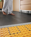 Exposed Ditra-Heat-E-HK Electric Floor Heating Cable Kit with tile floor, showing 120V twisted pair cables beneath tiles.
