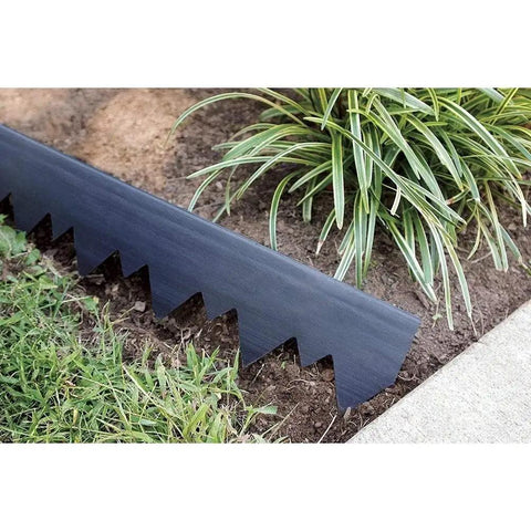 Close-up of the 4.5 inch straight-top black plastic edging from the Pound-In Landscape Edging Kit with Anchoring Stakes, dividing grass and plants