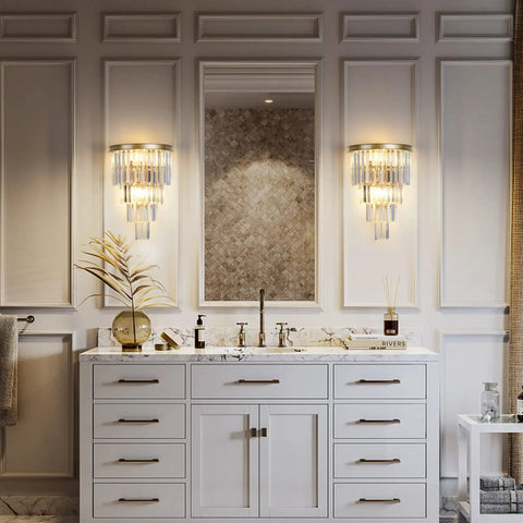 Slick Gold Crystal Four Tier Wall Sconce Lighting in bathroom, mounted beside mirror on gold-finished wall.